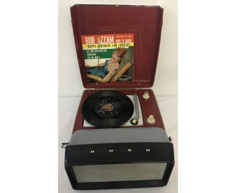 A vintage Bush "Top Ten" 9V portable record player, TRP 45. Serial No 360/07839. With built in LW radio and wire record rack 