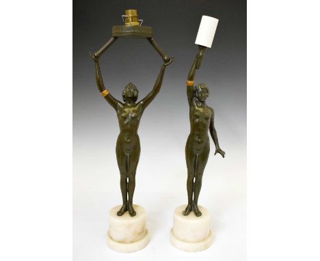 Two Art Deco-style spelter figural lamps in the form of nude dancers, both raised on cylindrical step marble bases, 48.5cm an