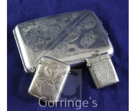 A George V silver cigarette case and two silver vesta cases, the former with engraved decoration, monogram and later inscript