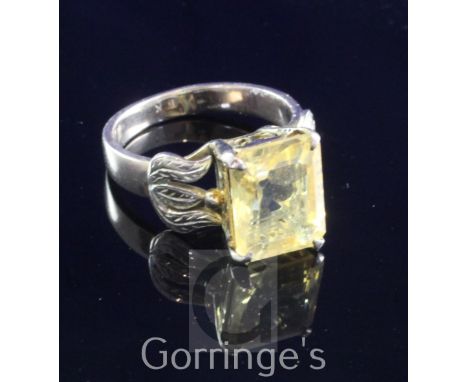 A 14ct gold and solitaire citrine set dress ring, with emerald cut stone and engraved foliate shoulders, size M.