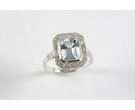 AN AQUAMARINE AND DIAMOND CLUSTER RING the step-cut aquamarine is set within a surround of two baguette-cut and fourteen circ