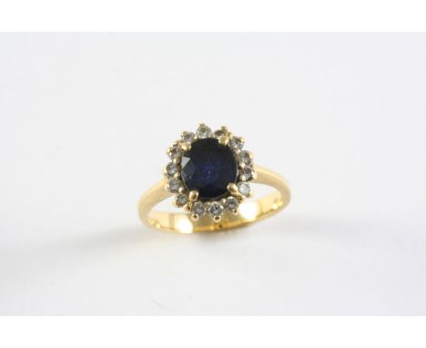 A SAPPHIRE AND DIAMOND CLUSTER RING the oval-shaped sapphire is set within a surround of circular-cut diamonds, in 18ct gold.