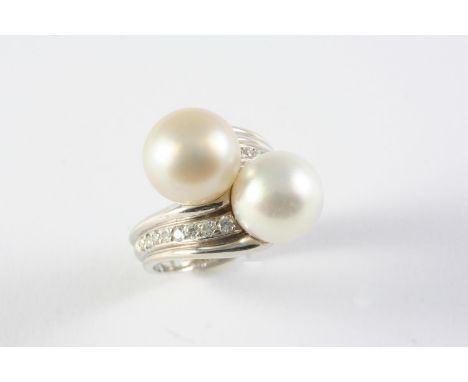 A CULTURED PEARL AND DIAMOND CROSS-OVER RING the cultured pearls measure  approximately 12.3mm each and are set with nine cir