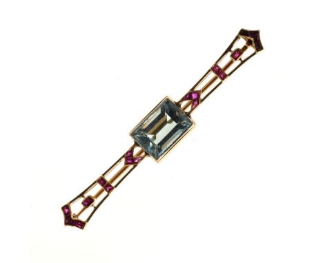 Aquamarine and calibré ruby brooch, unmarked, the step cut stone of approximately 11.5mm x 7.8mm x 5.8mm deep, with arrangeme