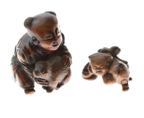 Japanese carved boxwood okimono, Meiji period, formed as a boy with a puppy, 6.5cm high together with a Japanese carved boxwo