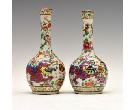 Pair of 19th Century Chinese Famille Rose spill vases, each having 'clobbered' decoration depicting dragons chasing a flaming