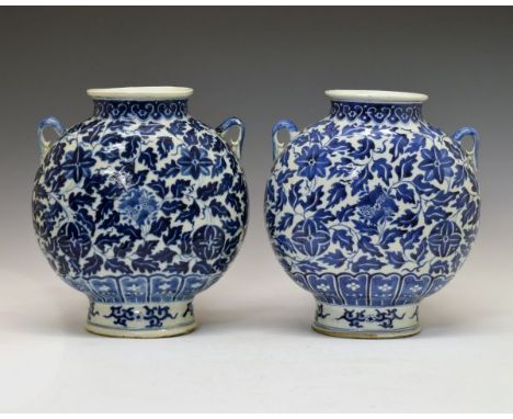 Pair of Chinese blue and white painted moon flask vases, each decorated with stylised foliage, handles to shoulders, Kangxi f