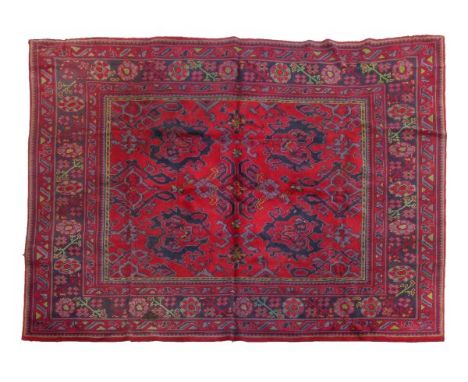 Mid 20th Century Turkey carpet, the red field with various hooked foliage designs within blue ground floral meander border an