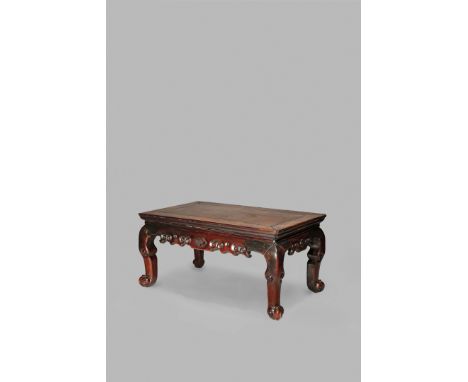 A CHINESE HARDWOOD RECTANGULAR LOW TABLE, KANG QING DYNASTY The scrolling frieze carved with a central flower motif, raised o