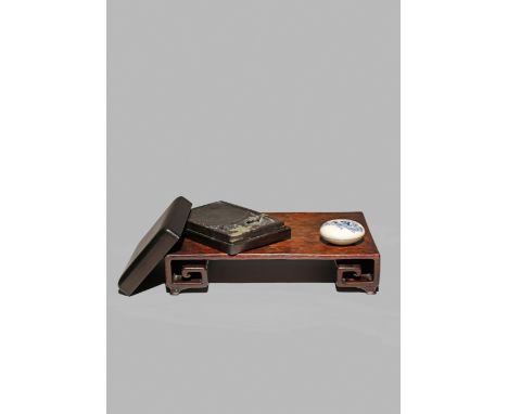 A CHINESE HARDWOOD LOW STAND, 19TH CENTURY Of rectangular form with scroll ends, together with an ink stone, carved with a bu