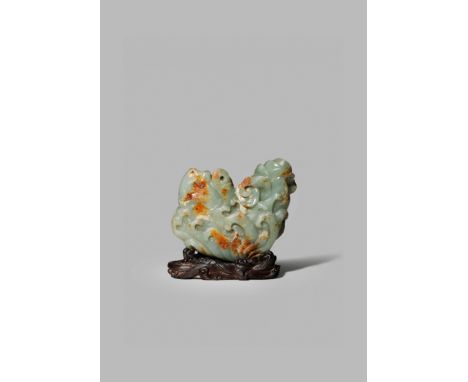 A CHINESE CELADON JADE CARVING OF A CARP, QING DYNASTY Emerging from crashing waves, its body curving upwards, the stone with