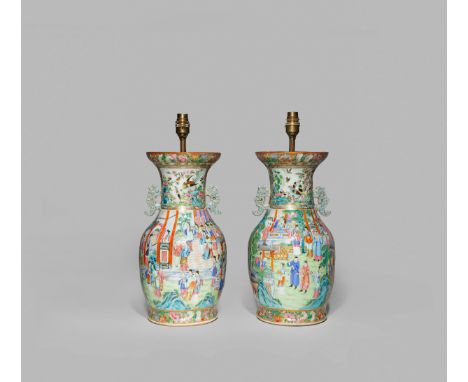 A PAIR OF CHINESE CANTON FAMILLE ROSE VASES, FIRST HALF OF THE 19TH CENTURY Decorated with many figures engaged in daily life