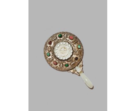 A CHINESE CIRCULAR JADE-MOUNTED HAND MIRROR, QING DYNASTY The handle formed from a pale celadon jade belthook with a dragon’s