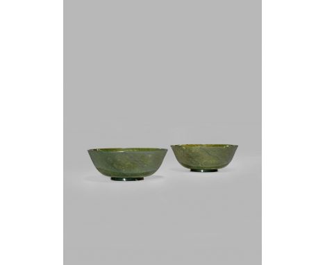 A PAIR OF CHINESE SPINACH-GREEN JADE BOWLS, 19TH/20TH CENTURY The plain bodies gently flaring, raised on a short ring foot, t