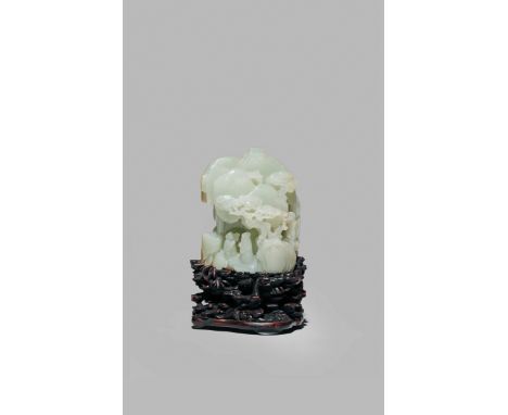 A CHINESE PALE CELADON JADE MOUNTAIN CARVING, QING DYNASTY OR LATER With three figures, a deer and two small buildings hidden