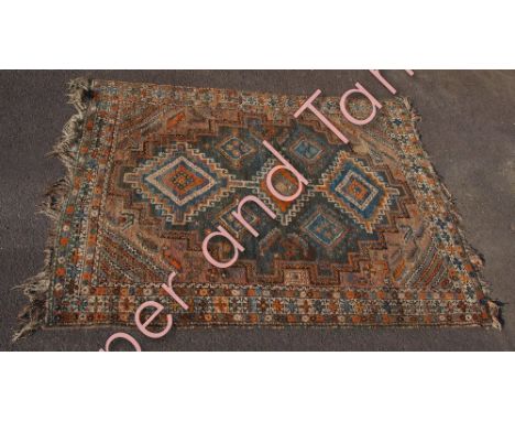 A Middle Eastern wool rug the central panel with three large medallions and smaller medallions within geometric guard stripes