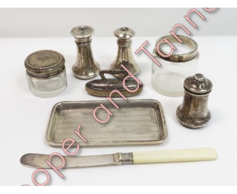 A silver pin tray; three silver peppers; a small silver mounted nail buff; a glass balm pot with a silver pull off cover; a s