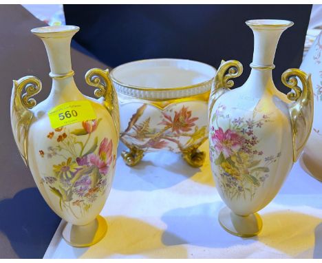 A pair of Royal Worcester elongated oval 2 handled vases decorated with flowers against a peach blush ground, height 23cm and