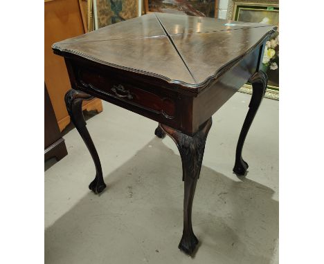 A mahogany card table with quatrefoil folding top, on cabriole legs and ball and claw feet 