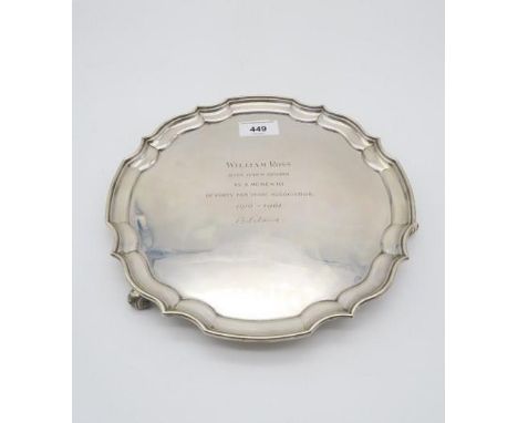 An Elizabeth II silver waiter, with chippendale style pie crust rim, supported on three feet, with presentational inscription