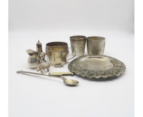 Two Indian white metal beakers, decorated with repousse scenes of wildlife, a similar copper bowl, an Indian white metal dish