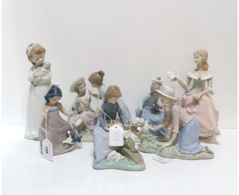 A Nao figure of a girl playing with rabbits, another two playing with dogs, another with a dove, a figure of two girls and a 