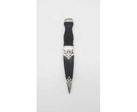 A sterling silver sgian dubh, in the lomond design, the black leather sheath with silver celtic knotwork casing, the textured