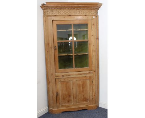 A late 18th century (with restorations) free-standing pine corner cupboard: the outset cornice above dentil and blind fret co