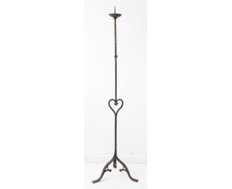 A large wrought iron pricket stick with unusual central heart motif and raised on tripod base (159cm high)