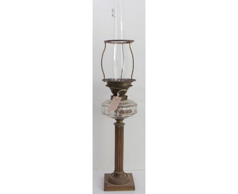 A late 19th/early 20th century brass lamp having facet-cut clear-glass reservoir and reeded column-style stem.