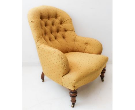 A 19th century mustard and red polka-dot upholstered (later) button-back armchair on short turned wooden legs with brass cast