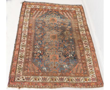 A mid-20th century hand-knotted Persian rug (wear): three style motifs against a worn cobalt and lighter blue ground, small d