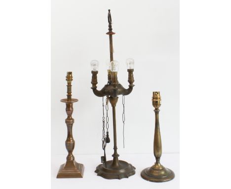 An early 20th century rise-and-fall brass oil lamp now fitted for electricity, a neoclassical-style candlestick (similarly fi