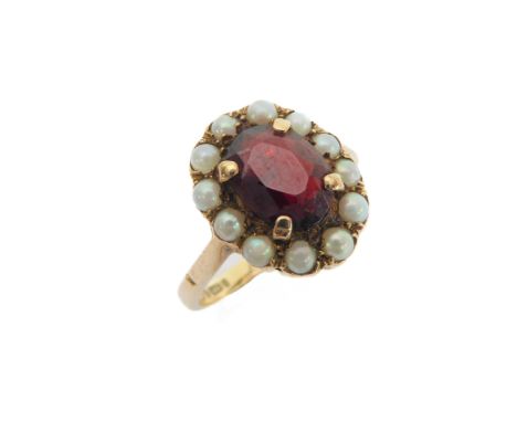 A 9-carat rose gold dress ring: centrally set with a hand-cut ruby/garnet surrounded by 12 seed pearls, probably 19th century