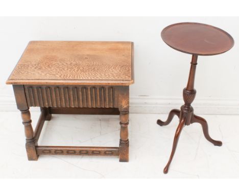 A small oak occasional table with linenfold panel sides and ends, single flush drawer and raised on turned legs united by str
