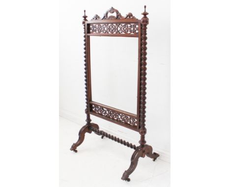 An ornate mid 19th century mahogany firescreen; the central handle above open fretwork and glazed section below flanked by ba
