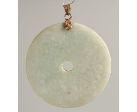A GOLD TOP CIRCULAR JADE PENDANT. 2.25ins diameter.