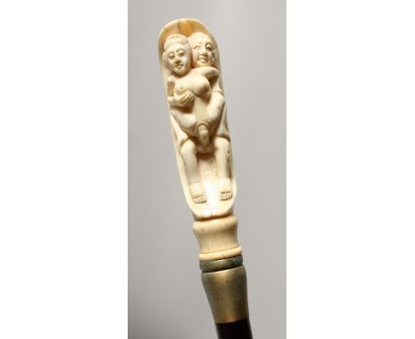 A BONE HANDLED WALKING STICK CARVE WITH AN EROTIC SCENE. 35ins long.