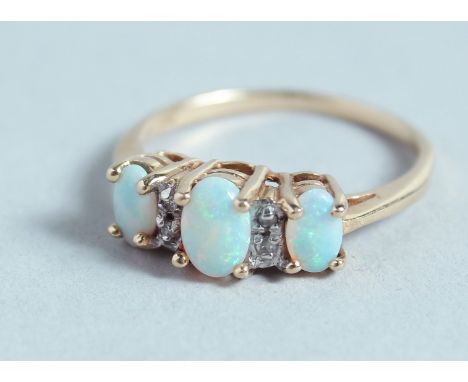 A THREE STONE OPAL AND DIAMOND RING.