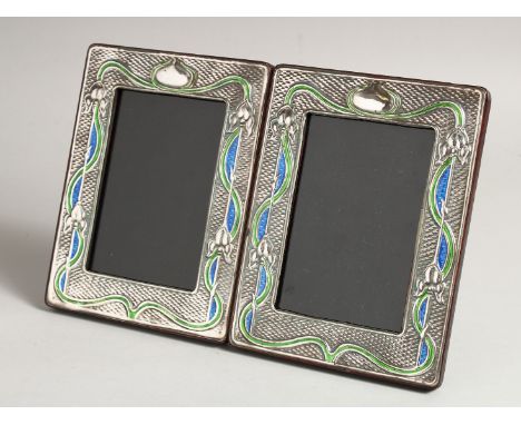 A PAIR OF SILVER AND ENAMEL PHOTOGRAPH FRAMES 7.5ins x 5.5ins.