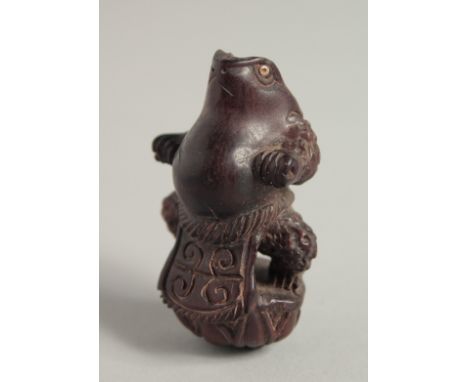 A CARVED WOOD FROG NETSUKE.