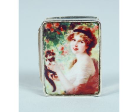 A SILVER AND ENAMEL PILL BOX with a girl and cat. 3cm long.