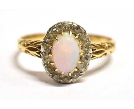 AN OPAL AND DIAMOND CLUSTER RING  The opal measuring approx. 7mm x 5mm, surrounded by 14 8 cut diamonds on a yellow metal sha