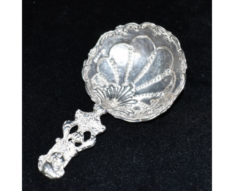 A SILVER CADDY SPOON  the spoon handle featuring an embossed cameo, the large bowl with fancy design, indistinct hallmark, sp