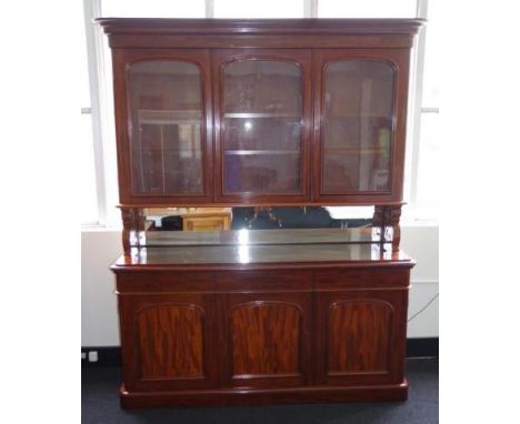 Good mahogany elevated bookcase with 3 glazed doors opening to adjustable shelves above a mirror backed open shelf, 3 drawers