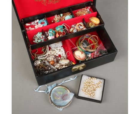 A jewellery case with contents of costume jewellery. Includes enamel earrings, simulated pearls, brooches etc.  