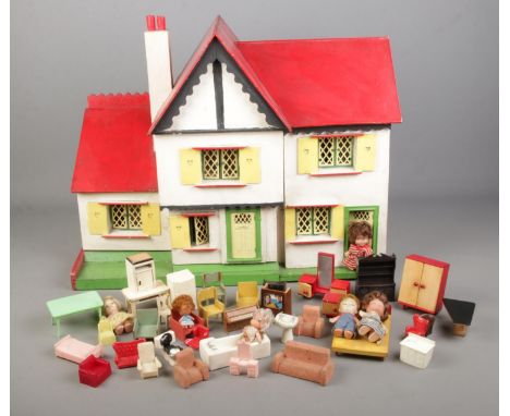 A vintage two storey dolls house with furniture.  