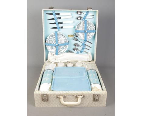 A vintage Brexton picnic hamper. Containing flasks, plates and cutlery.  Appears complete, with key.