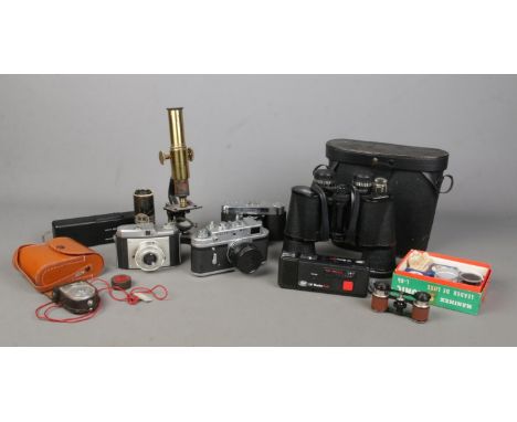 A collection of photography and magnifying equipment, to include cased binoculars, brass bodied microscope, opera glasses and