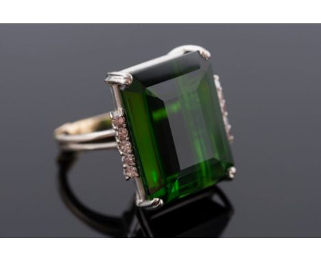 A green tourmaline single-stone ring:, the rectangular tourmaline approximately 20mm x 16mm, between single-cut diamond five-